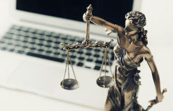 justice scales next to laptop