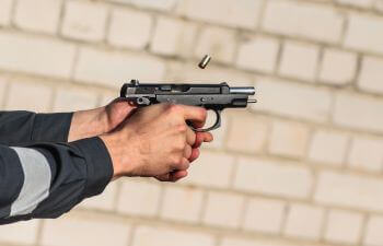 hands of the person shooting short gun